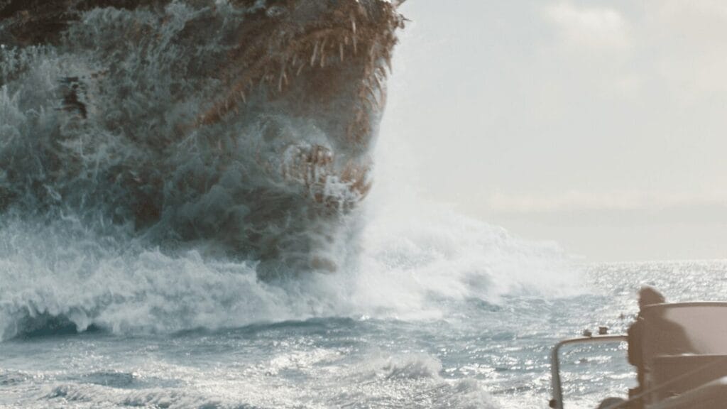 The mythological Kaiju known as Titan X raises its  sharp massive jaws out of the ocean as it chases a small boat in MONARCH: LEGACY OF MONSTERS Season 2. 