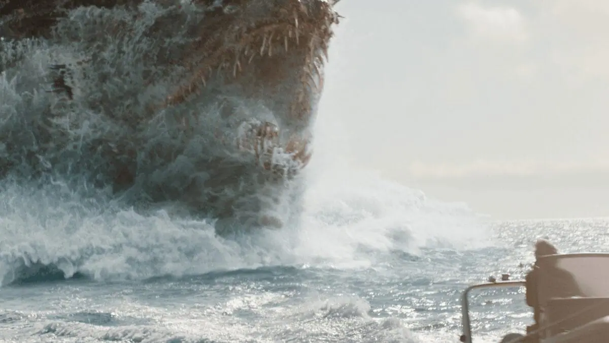 The mythological Kaiju known as Titan X raises its  sharp massive jaws out of the ocean as it chases a small boat in MONARCH: LEGACY OF MONSTERS Season 2. 