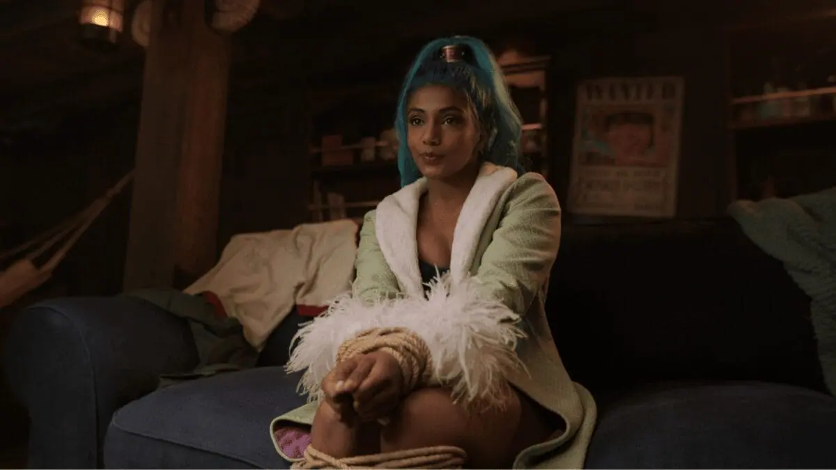 Charithra Chandran sports bright blue hair as the mysterious new character Miss Wednesday, who is a member of the Baroque Works guild of assassins in ONE PIECE Season 2 streaming only on Netflix.