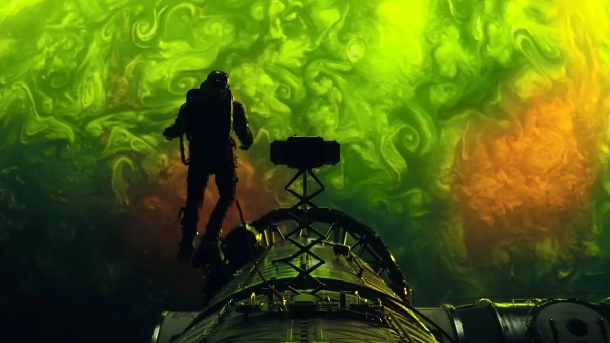 A beautiful shot of Ryan Gosling in an astronaut suit floating in space surrounded by a bright neon green and yellow energy field that highlights Greig Fraser's cinematography for PROJECT HAIL MARY. 