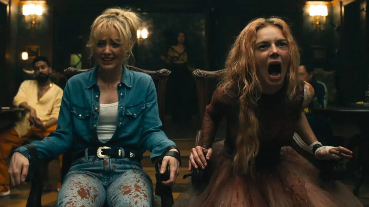 Kathryn Newton and Samara Weaving scream their lungs out in horror and agony as they find themselves tied to chairs next to each other as part of another twisted game in READY OR NOT 2: HERE I COME. 