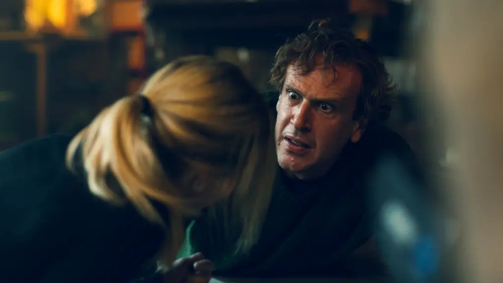 Jason Segel makes a hilarious and chaotic face as he and Samara Weaving try to survive in the dark action comedy OVER YOUR DEAD BODY. 