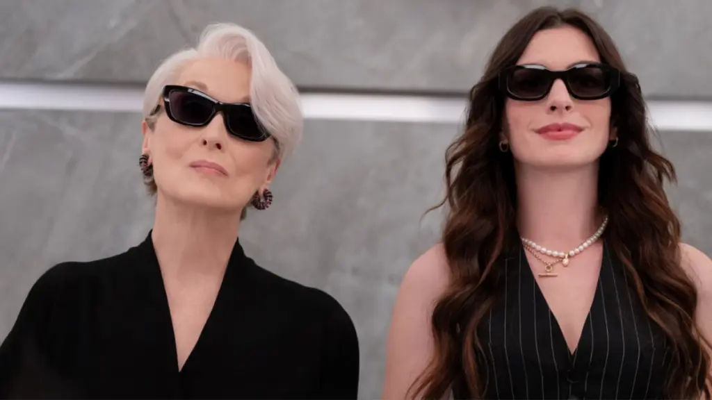 Meryl Streep and Anne Hathaway return as the iconic Miranda Priestly and Andy Sachs, both wearing cool black sunglasses as they stand side by side in an elevator, in THE DEVIL WEARS PRADA 2.