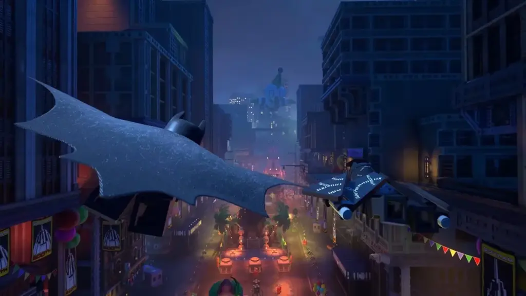 A shot of Batman using his cape to glide across the tall skyscrapers of the bustling Gotham City in the video game LEGO BATMAN: LEGACY OF THE DARK KNIGHT.