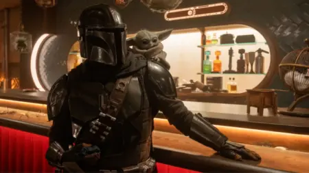 The Mandalorian and the adorable Baby Yoda enter a futuristic alien bar in the Star Wars movie spin-off THE MANDALORIAN AND GROGU.