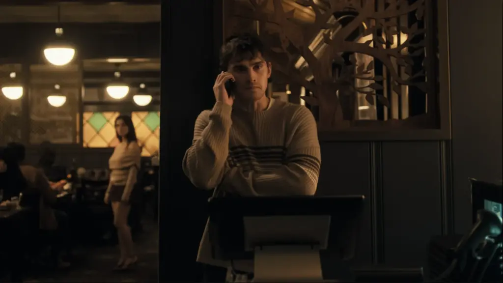 Michael Johnston nervously tries to make a phone call in a restaurant while his crazy obsessed girlfriend Nikki, played by Inde Navarrette, creepily watches from behind in the horror film OBSESSION. 