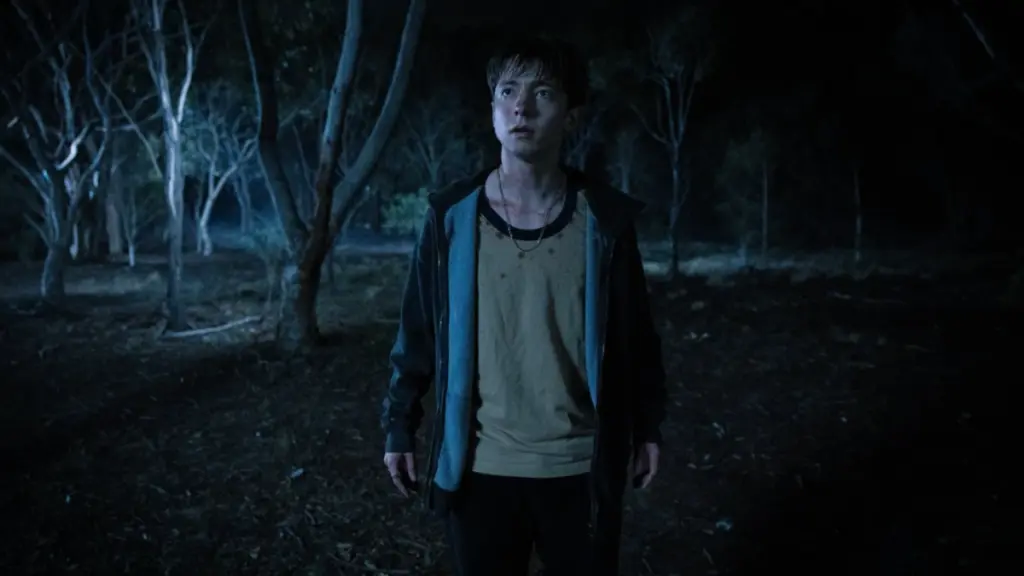 Joe Bird walks through an Australian park by himself in the queer horror film LEVITICUS.