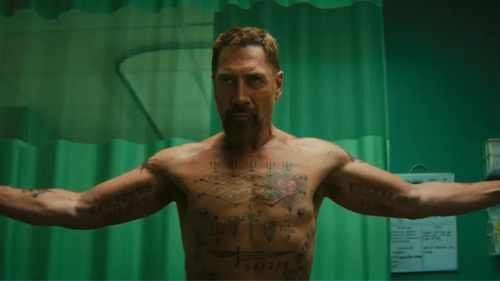 Javier Bardem gives a cold stare as he shows off his creepy body tattoos as a shirtless Max Cady in CAPE FEAR on Apple TV+. 