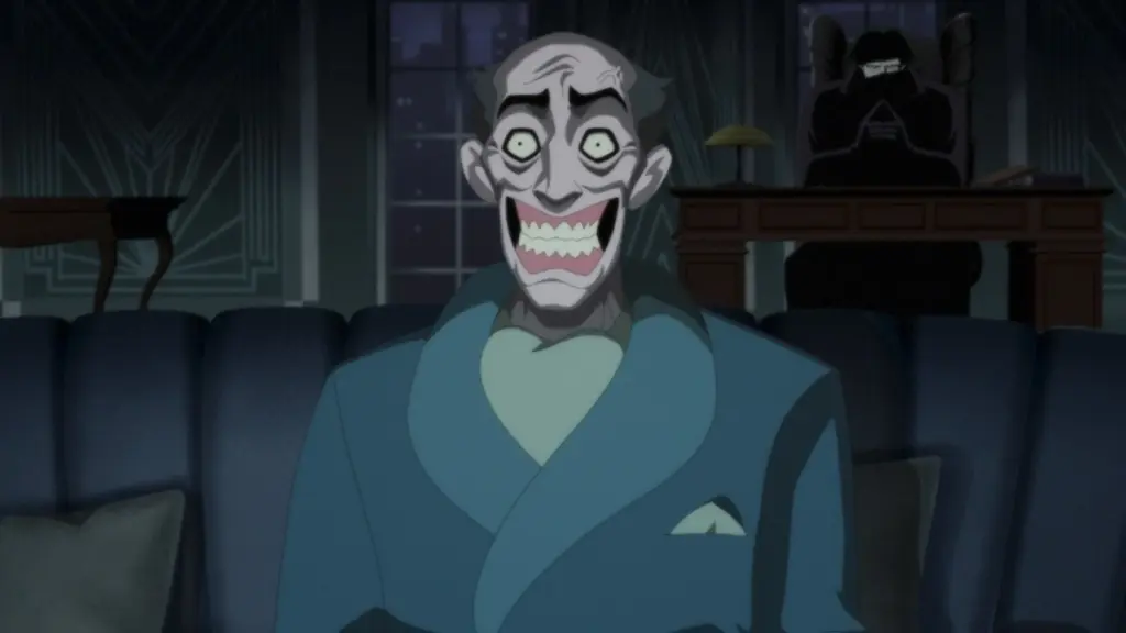 A male victim with a freakishly huge smile sits frozen on a chair while the Noir version of The Joker sits behind him in the shadows in BATMAN: CAPED CRUSADER Season 2. 
