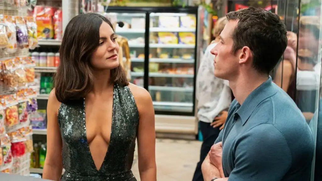 Monica Barbaro and Callum Turner share a devious glance while standing in a NYC convenience store in the dystopian romantic comedy ONE NIGHT ONLY.