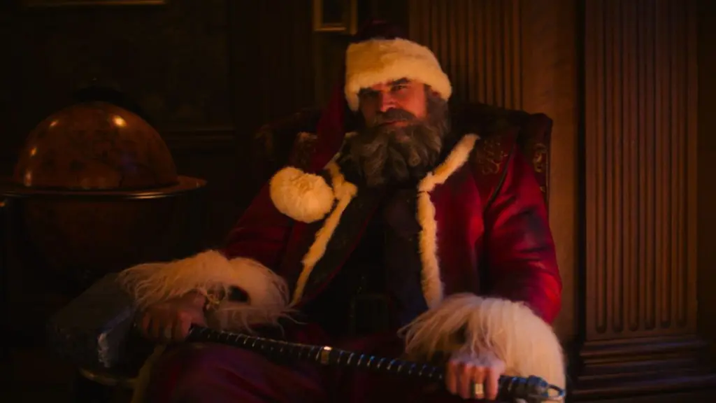 David Harbour returns as Santa Claus in his classic red and white costume while holding his battle hammer in the sequel VIOLENT NIGHT 2. 